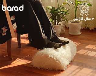 زیرپایی خانگی ارگولایف جلوی مبل منزل و پاهایی روی زیرپایی قرار گرفته است